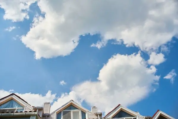Ein Haus mit blauem Himmel und Wolken im Hintergrund.