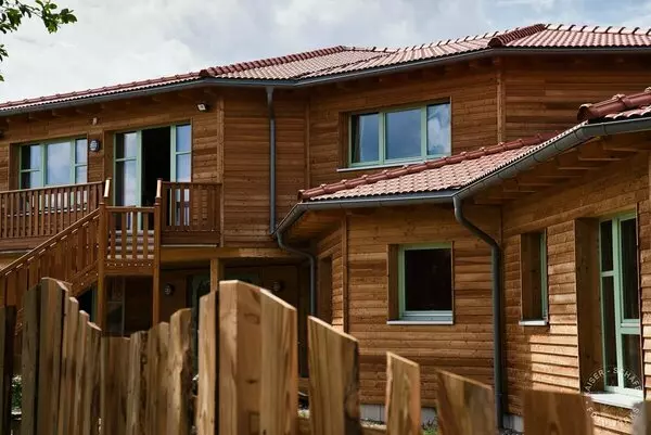 Ein Holzhaus mit einem Holzzaun und einer Holzterrasse.